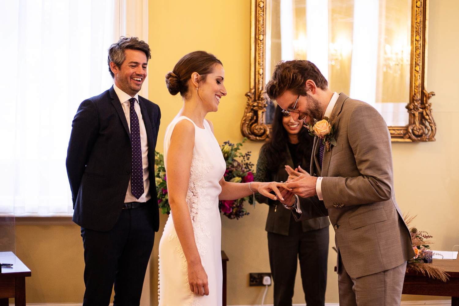 bride and groom laugh while exchanging rings